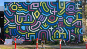 photo of a colourful art mural being painted on building at Araluen Diamond Creek